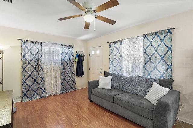 living room featuring ceiling fan, a healthy amount of sunlight, and wood-type flooring