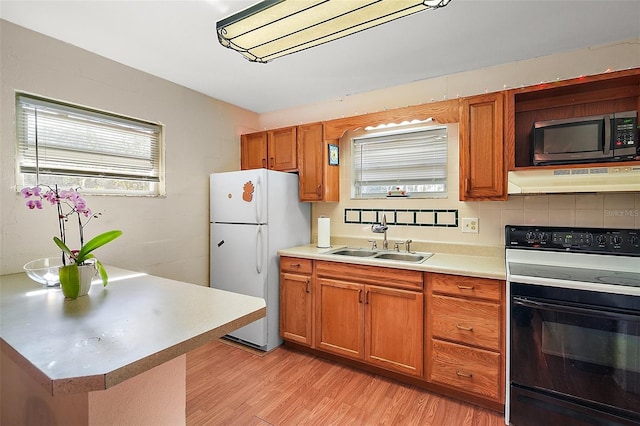 kitchen featuring white fridge, light hardwood / wood-style flooring, electric range, and sink