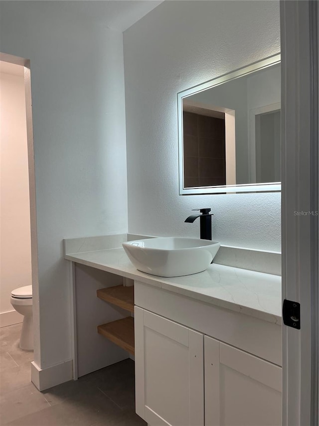 bathroom featuring vanity, tile patterned floors, and toilet