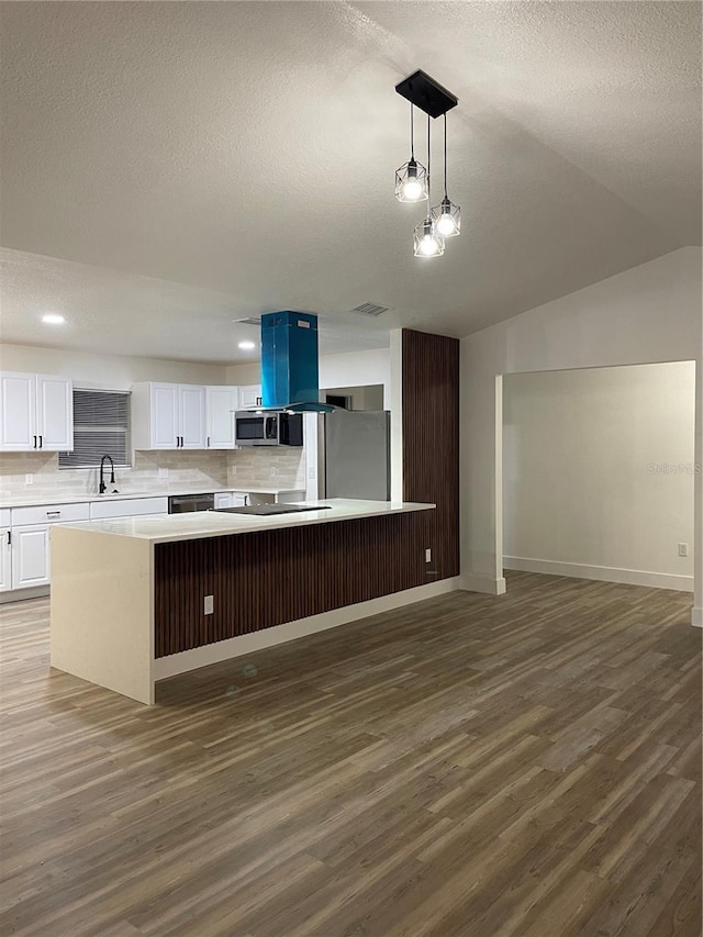 kitchen with appliances with stainless steel finishes, white cabinetry, dark hardwood / wood-style flooring, hanging light fixtures, and a center island