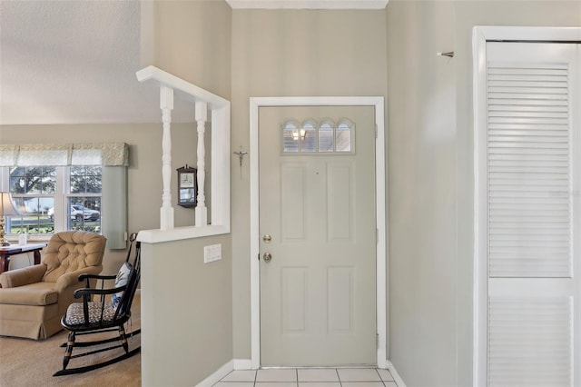 foyer featuring light tile patterned flooring, baseboards, and a textured ceiling