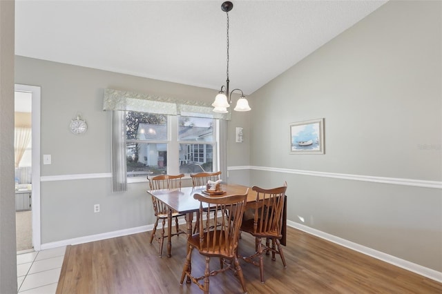 dining area with baseboards, lofted ceiling, and wood finished floors