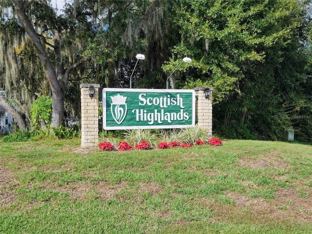 community / neighborhood sign featuring a yard