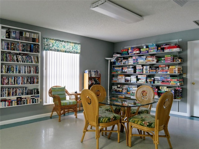 sitting room with a textured ceiling and finished concrete floors