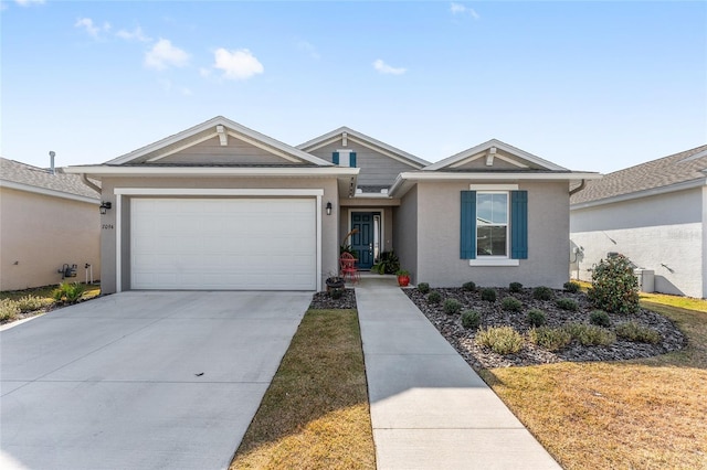 single story home with central air condition unit and a garage