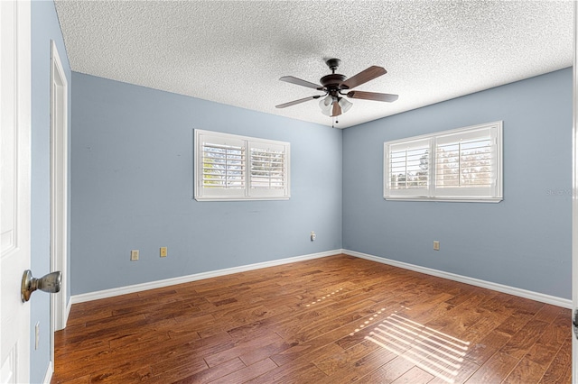 unfurnished room featuring ceiling fan, dark wood-type flooring, and a textured ceiling