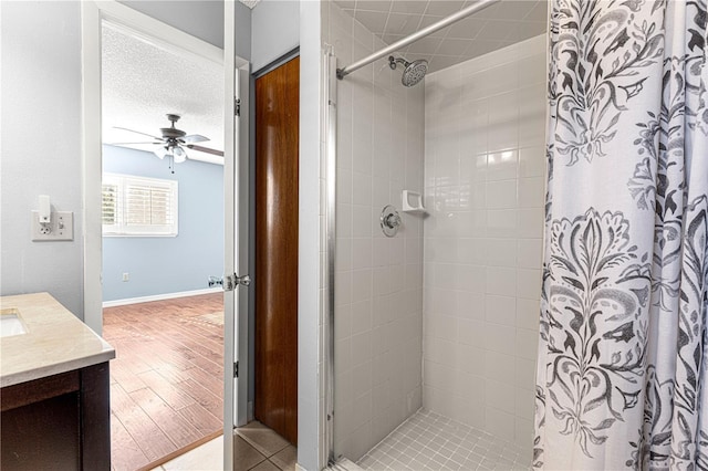 bathroom featuring vanity, ceiling fan, curtained shower, and a textured ceiling