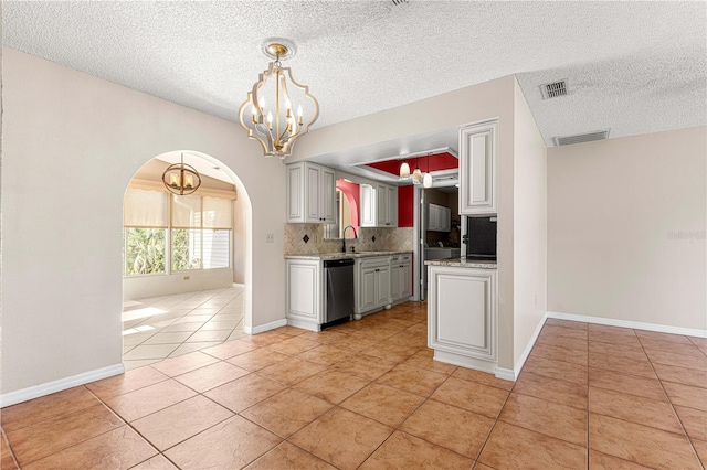 kitchen with dishwasher, decorative light fixtures, backsplash, a chandelier, and light tile patterned floors