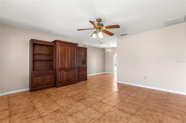 unfurnished room with ceiling fan with notable chandelier, a textured ceiling, and light tile patterned floors