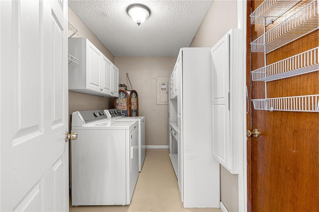 laundry area featuring cabinets, a textured ceiling, and washing machine and clothes dryer