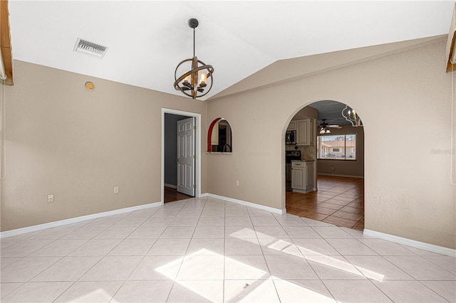 tiled spare room featuring ceiling fan with notable chandelier and lofted ceiling