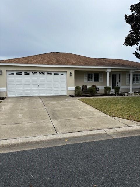 single story home featuring a garage and a front lawn