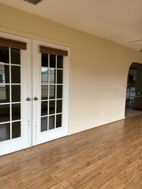 spare room with light hardwood / wood-style floors and french doors