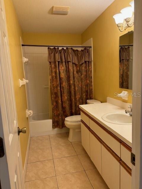 full bathroom with tile patterned flooring, vanity, shower / bath combo, and toilet