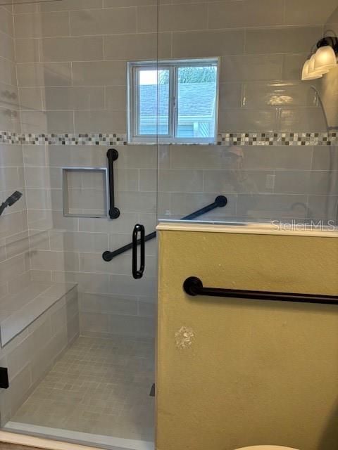 bathroom featuring a shower with shower door