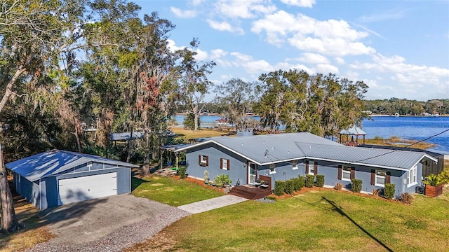 view of front facade featuring a water view, a front lawn, an outdoor structure, and a garage