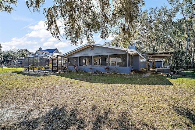 back of house featuring a lanai, a sunroom, and a lawn