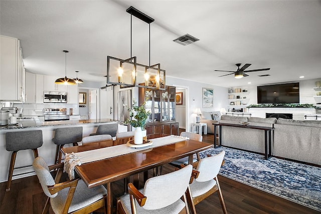 dining room featuring ceiling fan, dark hardwood / wood-style flooring, and sink