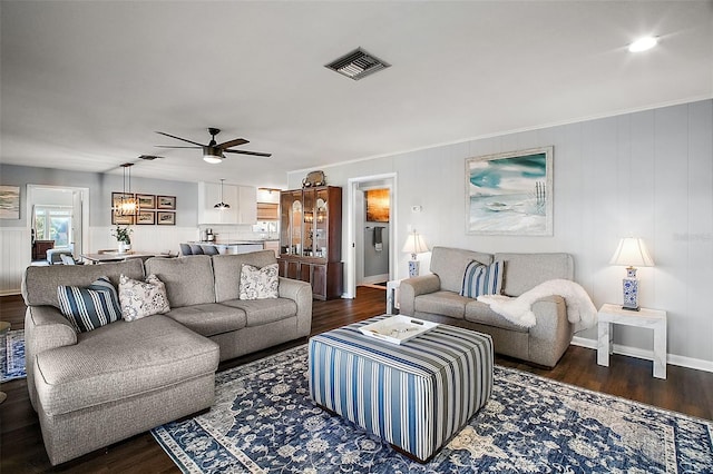 living room featuring ceiling fan and dark hardwood / wood-style flooring