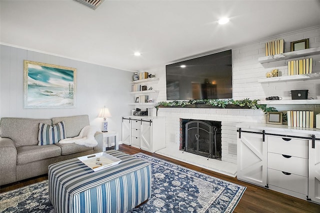 living room with a brick fireplace and dark hardwood / wood-style floors