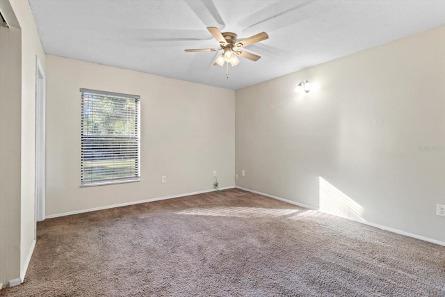 carpeted spare room featuring ceiling fan