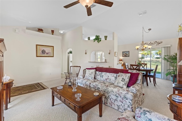 living room with ceiling fan with notable chandelier, lofted ceiling, and light carpet