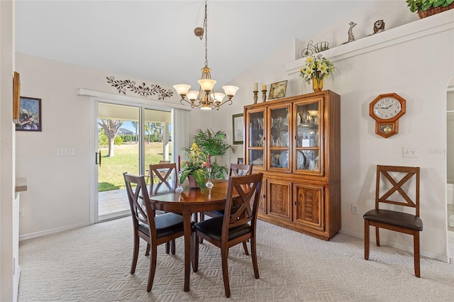 carpeted dining area with lofted ceiling and a notable chandelier