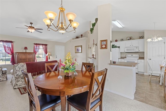 dining room featuring ceiling fan with notable chandelier and vaulted ceiling