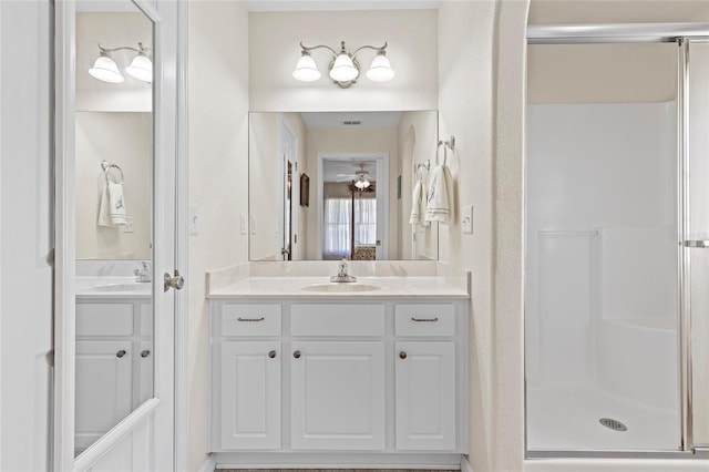 bathroom featuring a shower with door and vanity