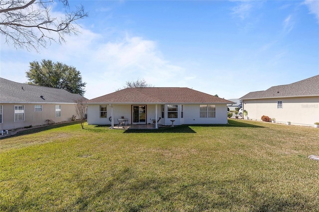 rear view of house with a patio and a lawn