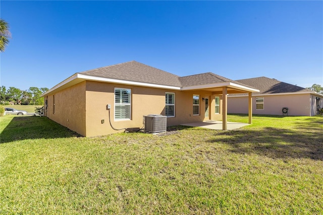 back of house with a patio area, a lawn, and central air condition unit