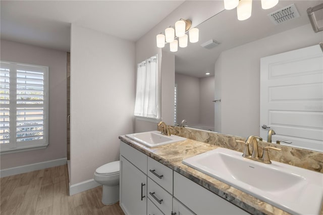 bathroom with toilet, vanity, and hardwood / wood-style flooring