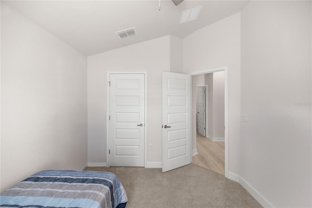 bedroom with lofted ceiling and light carpet