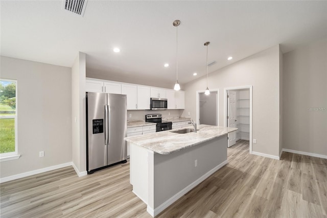 kitchen featuring decorative light fixtures, white cabinetry, a center island with sink, and appliances with stainless steel finishes