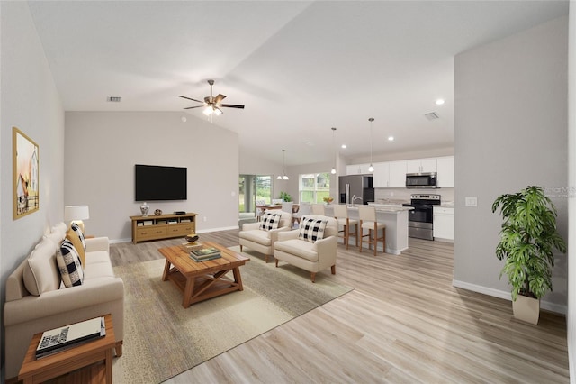 living room with light wood-type flooring, ceiling fan, and lofted ceiling