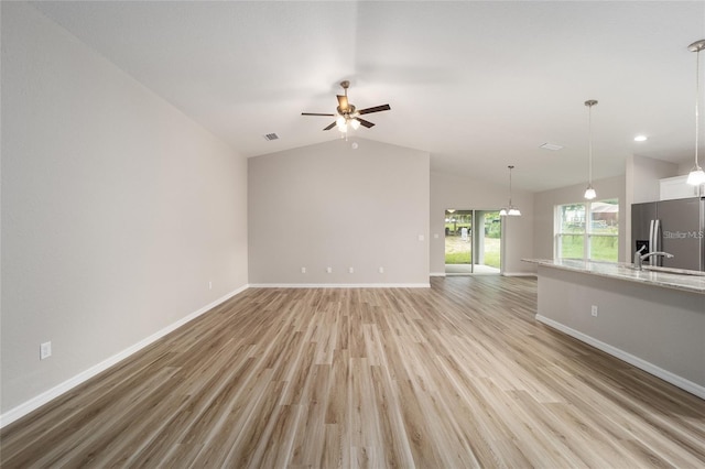 unfurnished living room featuring ceiling fan, light hardwood / wood-style flooring, and vaulted ceiling