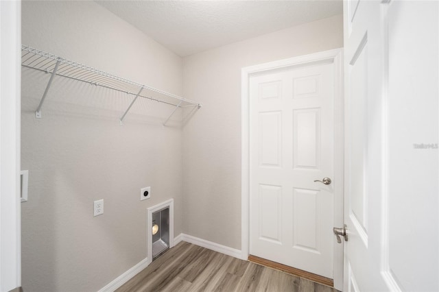 clothes washing area featuring electric dryer hookup, hardwood / wood-style floors, and a textured ceiling