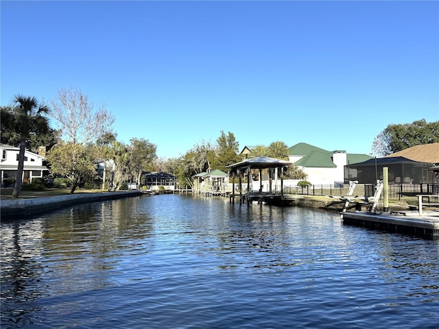 view of dock featuring a water view and fence