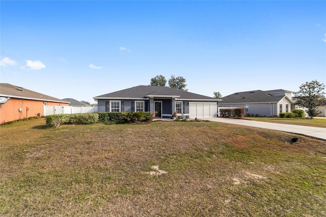 ranch-style house featuring a garage and a front lawn