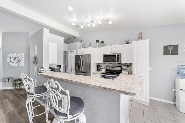 kitchen featuring kitchen peninsula, a breakfast bar area, and appliances with stainless steel finishes