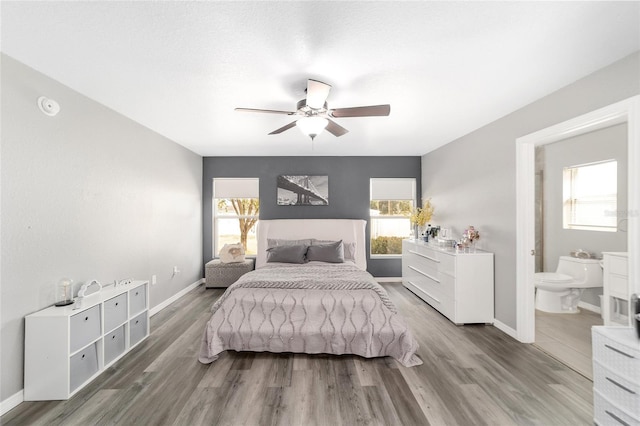 bedroom with ceiling fan, connected bathroom, and hardwood / wood-style flooring