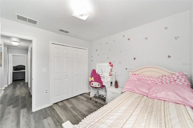 bedroom with hardwood / wood-style floors, a closet, and a textured ceiling