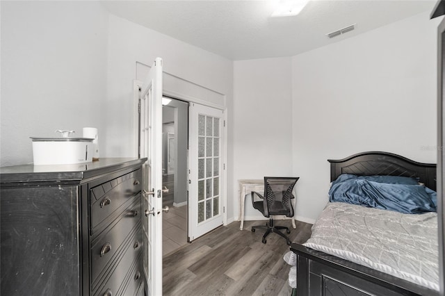 bedroom with hardwood / wood-style flooring and french doors