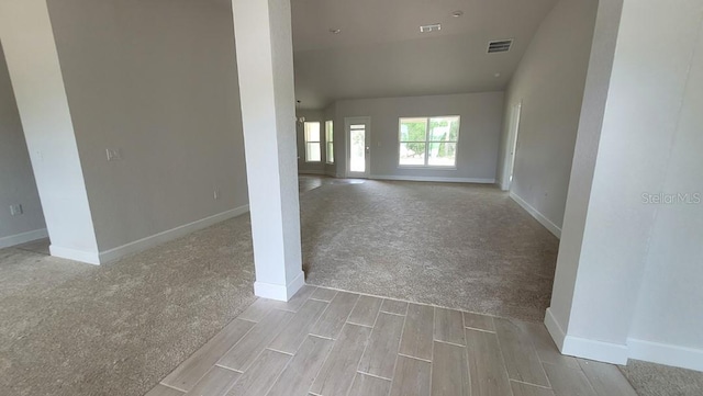 unfurnished living room featuring baseboards, carpet, visible vents, and wood finished floors