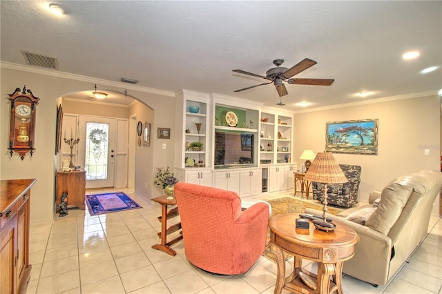 tiled living room with built in features, ceiling fan, and ornamental molding