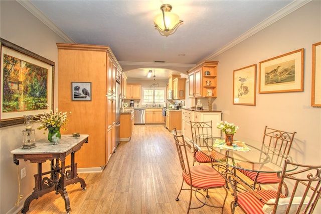 dining space with sink, light hardwood / wood-style flooring, and ornamental molding