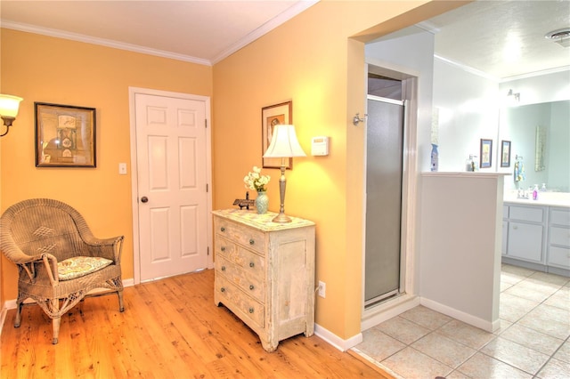 living area with light hardwood / wood-style floors and ornamental molding