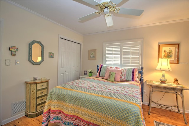 bedroom featuring light hardwood / wood-style flooring, a closet, ceiling fan, and ornamental molding