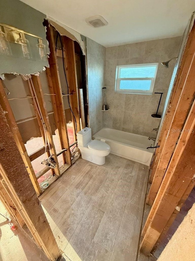 bathroom with tiled shower / bath and toilet