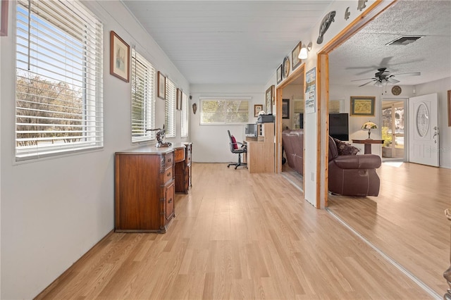 hallway featuring a textured ceiling and light hardwood / wood-style flooring